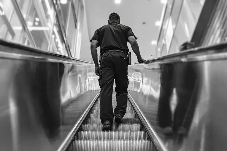 2-ISJ- What is Corporate Security? Security Guard Riding Escalator